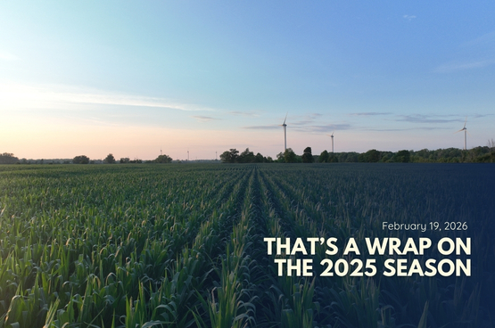 Cornfield at sunset with wind turbines; text reads “That’s a wrap on 2025 season.”